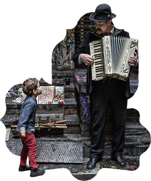 An accordion player in a bowler hat performing for a child