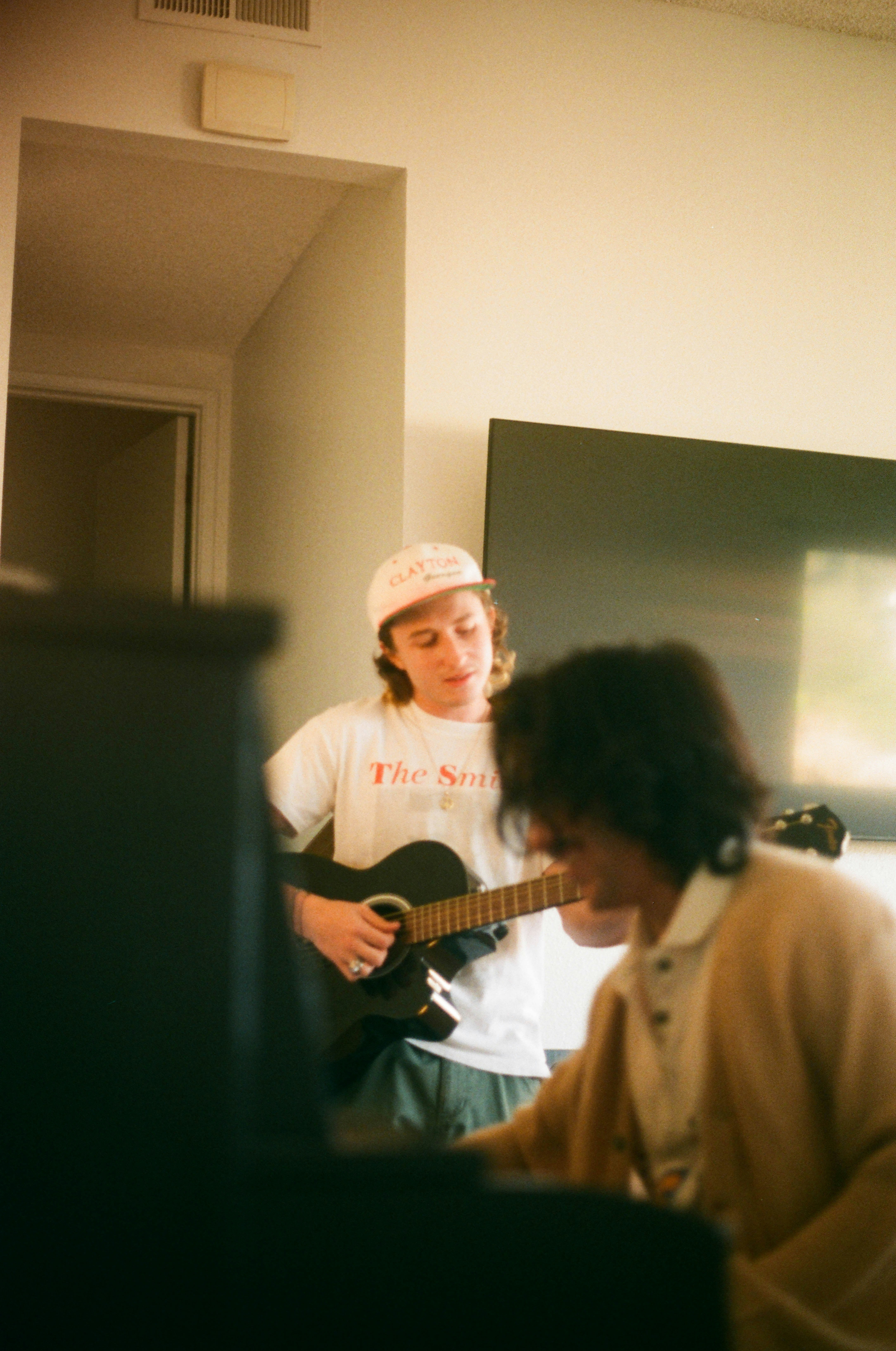 Two friends playing guitar and keyboard together at home
